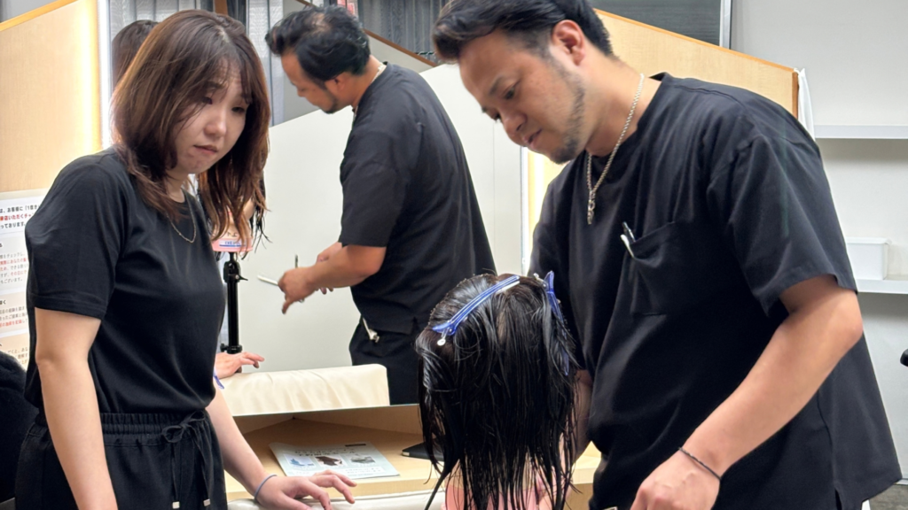 磐田市の美容室フェイスでスタッフ同士が技術を共有している様子