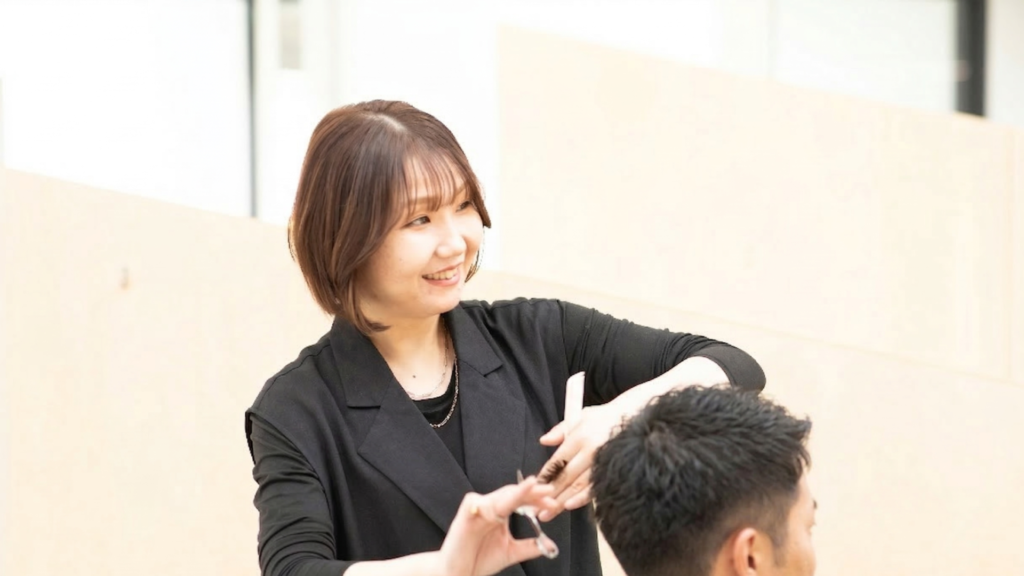 メンズスタイルが得意な女性スタッフが、会話なしで静かに過ごしたい男性のお客様を丁寧にカットしている様子