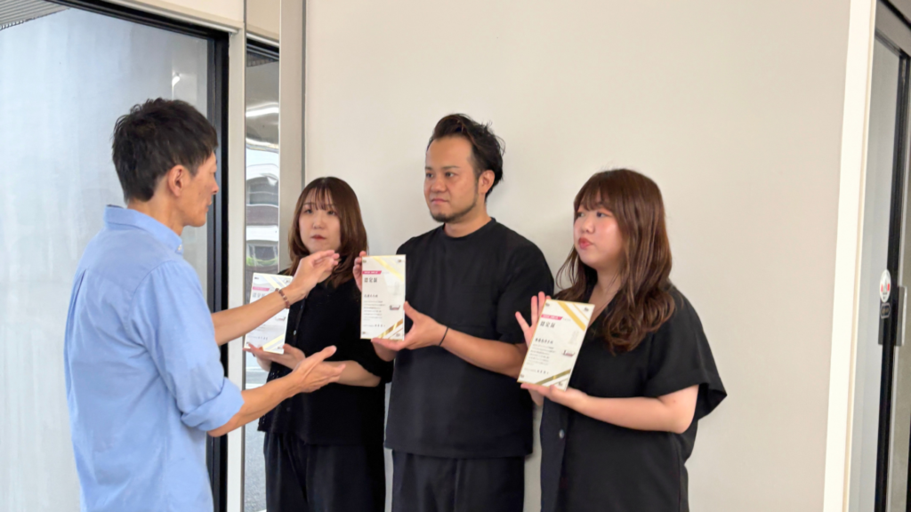 カメラマン横田さんがフェイスのスタッフにポーズの指示をしている様子