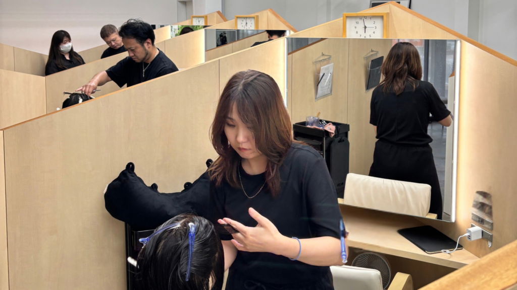 磐田市の美容室フェイスでスタッフ同士が技術を共有している様子